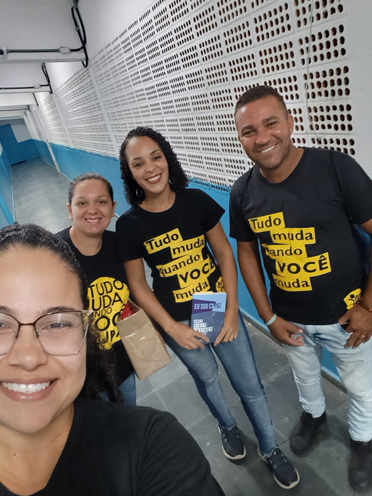 Equipe de capelania com camisetas do projeto, segurando o livro Eu Sou Capaz