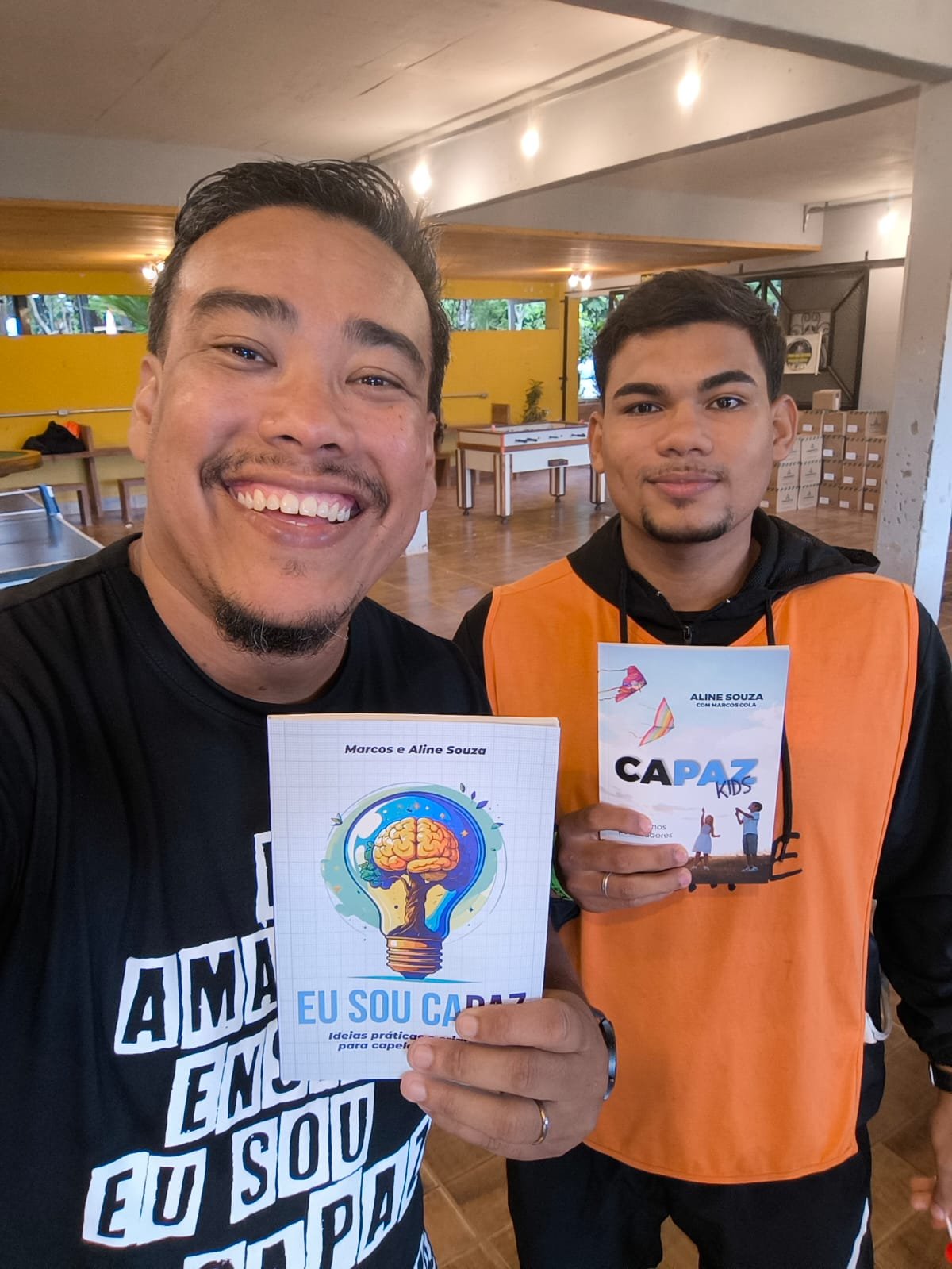 Marcos e um capelão apresentando os livros Eu Sou Capaz e Capaz Kids